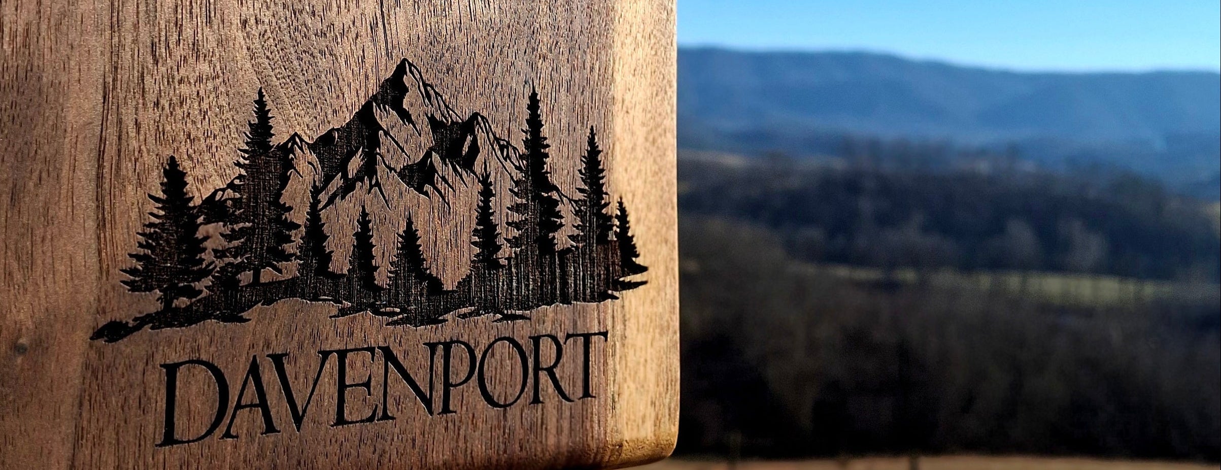 Wooden product with 'Davenport' engraving against a scenic background